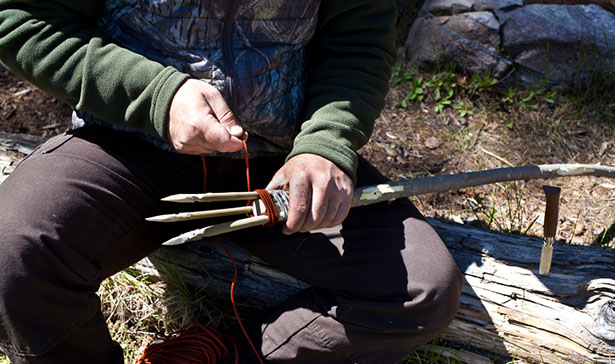 man making fishing spear