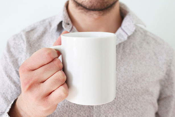 man white shirt holding coffee mug