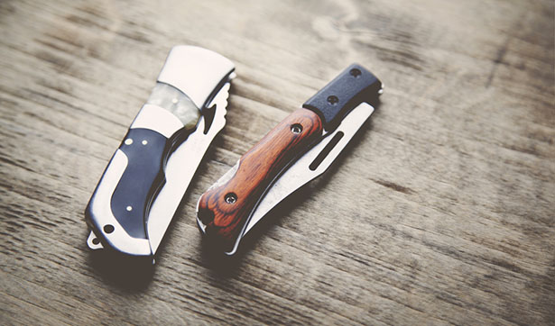 two folding pocket knives on table
